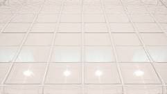 strong clear PVC tubing, intricate network, woven pattern, photorealistic, on a tiled floor reflecting overhead lights, highly detailed, vibrant shine, 8K resolution, clear as glass, spotlight lighting, shot with a 100mm lens.